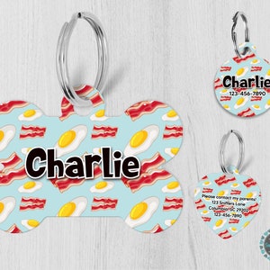 May include: A blue and white bone-shaped dog tag with a pattern of bacon and eggs. The tag has the name "Charlie" printed on it.