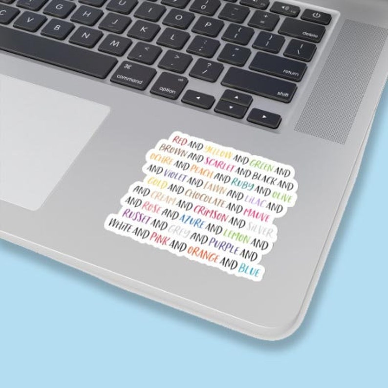 May include: A rectangular sticker featuring a list of colour names printed in their corresponding ink colours. The text includes words like red, yellow, green, brown, scarlet, black, ochre, peach, ruby, olive, violet, fawn, lilac, gold, chocolate, mauve, cream, crimson, silver, rose, azure, lemon, russet, grey, purple, white, pink, orange, and blue.