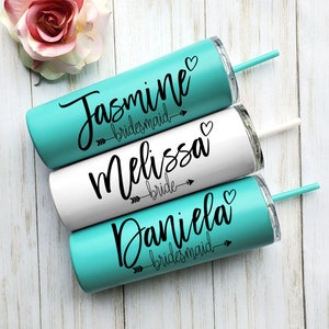 Pode incluir: Tr&ecirc;s copos turquesa e branco com texto preto e setas. Os copos s&atilde;o etiquetados como "Jasmine bridesmaid", "Melissa bride" e "Daniela bridesmaid".