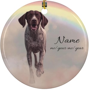 May include: Circular ceramic ornament depicting a German Shorthaired Pointer dog with brown and white markings, running forward. The ornament has a gold hanging string and the text "Name" and "mo/year-mo/year".