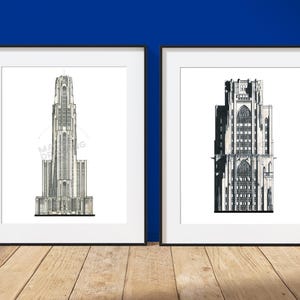 May include: Two framed wall art prints featuring black and white architectural line drawings of tall gothic-style buildings. The left print shows a slender tower, while the right print depicts a wider structure with intricate window details.