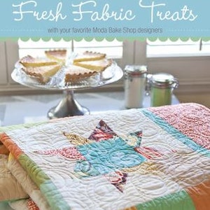 Könnte beinhalten: Eine Steppdecke mit einem sternförmigen Design in Blautönen, Grün, Gelb und Rot. Die Steppdecke ist aus Stoffresten gefertigt und hat ein gestepptes Muster. Der Text "16 YUMMY PROJECTS TO SEW FROM JELLY ROLLS, LAYER CAKES & MORE" ist unten auf der Steppdecke aufgedruckt.