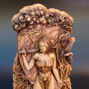 May include: A wooden sculpture of a woman holding a sword, with a background of clouds and birds. The sculpture is carved in a realistic style and has a detailed finish.
