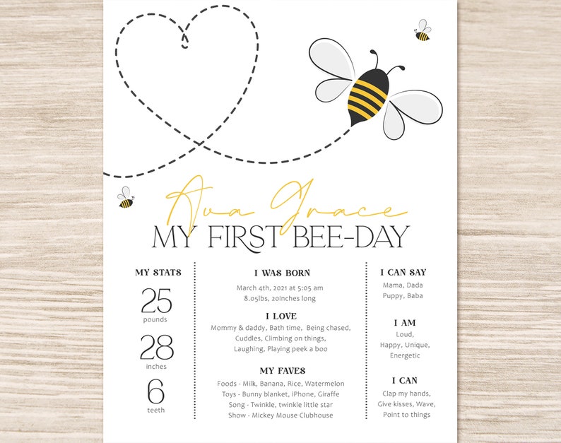 May include: A white and yellow baby announcement card with a bee theme. The card features a heart shape made of dotted lines, a bee illustration, and the text "Ava Grace My First Bee-Day". The card also includes the baby's stats, including weight, height, and number of teeth.
