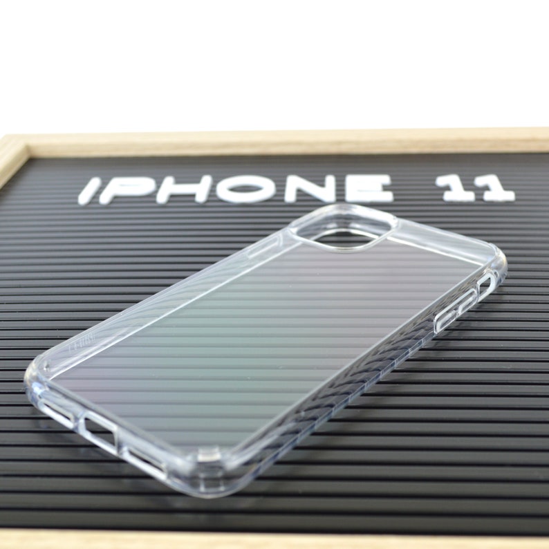 May include: Clear iPhone 11 phone case. The case is transparent and has a ridged design. The words "IPHONE 11" are displayed on a black background.