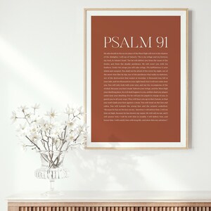 May include: A printable wall art poster with a brown background and white text. The poster features the text "PSALM 91" in a large font at the top and a passage of scripture from the Bible below.