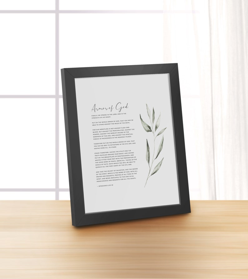 K&ouml;nnte beinhalten: Ein gerahmter Druck mit einem schwarzen Rahmen und wei&szlig;em Hintergrund. Der Druck zeigt eine Aquarell-Illustration eines gr&uuml;nen, belaubten Zweigs und Text, der "R&uuml;stung Gottes" lautet, sowie eine Passage aus Epheser 6,10-18.