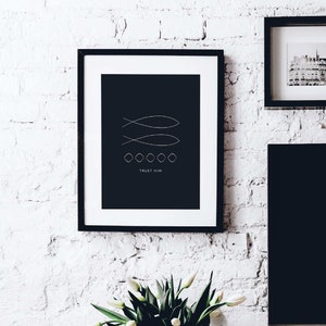 May include: Black and white minimalist print with two stylized fish and the text "TRUST HIM" in a black frame on a white brick wall.