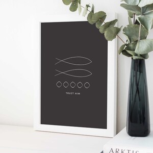 May include: A black and white minimalist print with two stylized fish symbols and the text "TRUST HIM" below. The print is framed in a white frame and is displayed on a white surface.