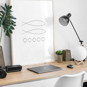 May include: A minimalist black and white line art print of two fish and five circles in a wooden frame, a laptop, a black speaker, a white desk chair, a black desk lamp, a white moon lamp, and two small potted plants on a light wood desk.