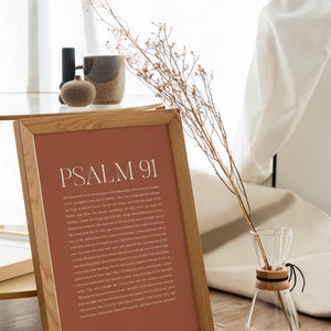 May include: A framed print with a brown background and white text. The text is a passage from Psalm 91 of the Bible. The frame is made of wood and has a natural finish.