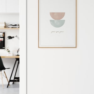 K&ouml;nnte beinhalten: Ein gerahmter Druck mit einem minimalistischen Design, das zwei sich &uuml;berlappende Halbkreise in Rosa- und Blaut&ouml;nen zeigt. Der Text "grace upon grace" ist darunter in Kursivschrift geschrieben.