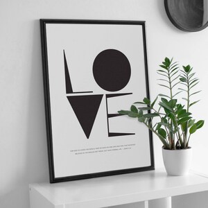 May include: Black and white typography print with the word "LOVE" in bold, geometric shapes. The print includes a quote from John 3:16: "For God so loved the world, that he gave his one and only Son, that whoever believes in him shall not perish but have eternal life."