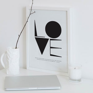 May include: A black and white framed print with the word "LOVE" in bold, geometric shapes. The print includes a bible verse: "For God so loved the world, that he gave his one and only Son, that whoever believes in him shall not perish but have eternal life." - John 3:16