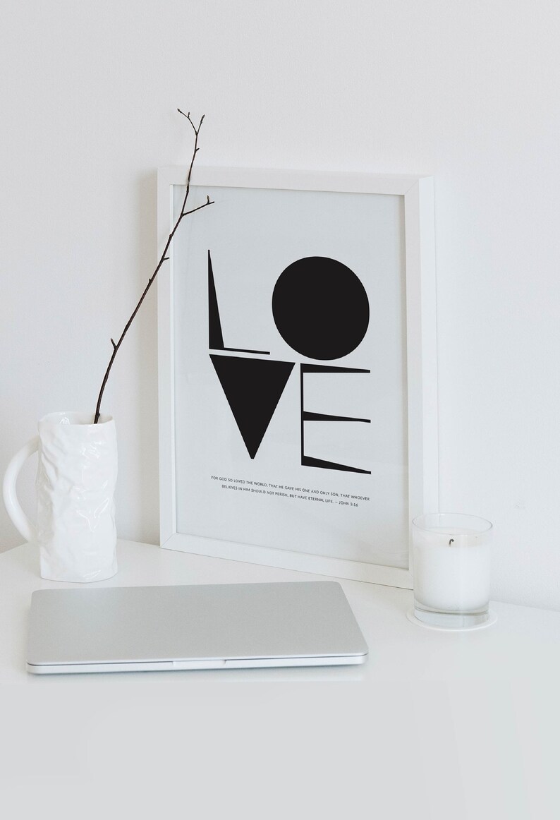 May include: A black and white framed print with the word "LOVE" in bold, geometric shapes. The print includes a bible verse: "For God so loved the world, that he gave his one and only Son, that whoever believes in him shall not perish but have eternal life." - John 3:16