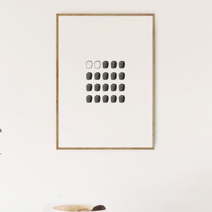 May include: A framed black and white minimalist art print with a grid of 20 small squares. The top row has three squares, the second row has four squares, and the remaining rows have five squares. The squares are filled with black except for the first two squares in the top row, which are white.