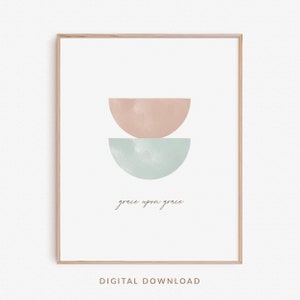 K&ouml;nnte beinhalten: Ein digitaler Download-Druck mit einem minimalistischen Design, das zwei sich &uuml;berlappende Halbkreise in Rosa- und Blaut&ouml;nen zeigt. Der Text "grace upon grace" ist darunter in Kursivschrift geschrieben.