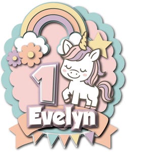 Puede incluir: Un recorte de papel en capas de colores pastel, con un unicornio, un arcoíris y el número 1. El nombre "Evelyn" se muestra debajo. El diseño incluye una estrella, flores y una pancarta con triángulos pastel.