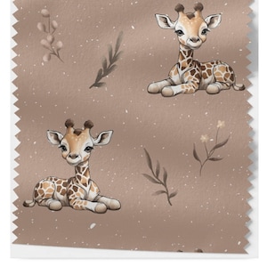 Könnte beinhalten: Ein brauner Stoff mit einem sich wiederholenden Muster aus einer niedlichen Giraffe mit braunen Flecken und einem kleinen, belaubten Zweig mit weißen Blüten. Der Hintergrund ist hellbraun mit einer dezenten, gesprenkelten Textur.