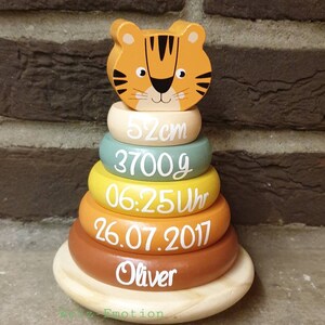 Könnte beinhalten: Ein Holz-Steckspielzeug mit einem Tigerkopf. Das Spielzeug hat Ringe mit den Maßen: 52cm, 3700g, 06:25 Uhr, 26.07.2017 und dem Namen Oliver. Die Basis ist helles Holz. Ein schönes Geschenk.