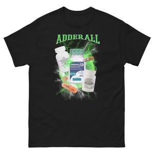 Puede incluir: Camiseta negra con la palabra "ADDERALL" en letras verdes en bloque sobre un gráfico de frascos de pastillas y cápsulas con rayos verdes. La camiseta tiene cuello redondo y mangas cortas.