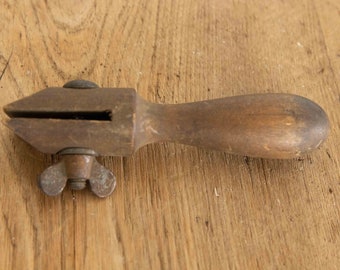 Antique primitive wood handled tool with patina covered screw.