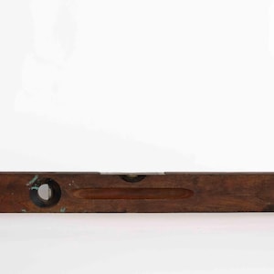 May include: A wooden level with a brass bubble level and a dark brown finish.