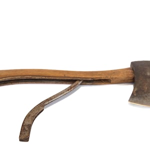 May include: An antique axe with a wooden handle and a curved metal blade. The axe head is made of dark, aged metal. The handle is a light brown color. The axe is set against a white background.