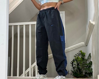 Vintage Nike Cuffed Leg doublé de maille de pantalon de survêtement bas de survêtement taille M unisexe rare vintage des années 00 noir avec doublure bleue