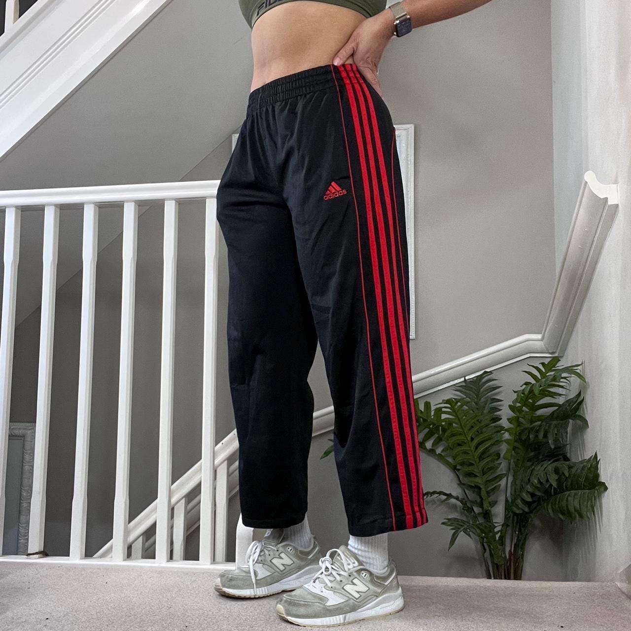 black adidas track pants with red stripes