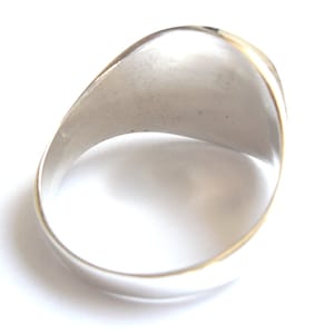 Puede incluir: Un anillo de plata con una superficie lisa y redondeada. El anillo est&aacute; dise&ntilde;ado para ser usado en el dedo.