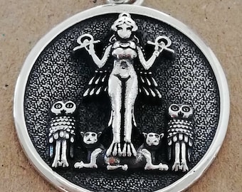 May include: Silver pendant featuring a stylised female figure with outstretched arms, two owls, and two cats. The pendant is circular and has a textured surface.