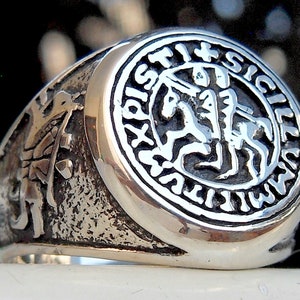 Op de afbeelding: Een zilveren ring met een gedetailleerd ontwerp van een ridder te paard. De ring is gegraveerd met "SIGILLVM REGIS SICILIE" rond de buitenrand.