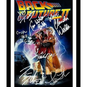May include: A movie poster for Back to the Future Part II featuring Michael J. Fox and Christopher Lloyd. The poster is signed by the cast members, including Michael J. Fox, Christopher Lloyd, Lea Thompson, Thomas F. Wilson, and Claudia Wells.