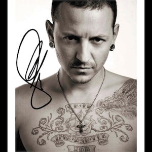 May include: Black and white portrait of a man with a tattoo on his chest. The tattoo features a rose, a cross, and a banner with the text "JMB DSBT VB" and "UDB".