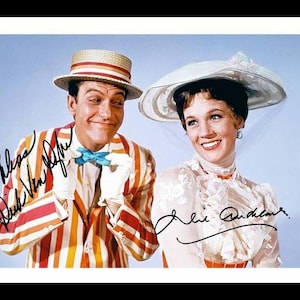 May include: A colour photograph featuring two individuals with signatures. One wears a straw boater hat, a red and yellow striped blazer, and a blue bowtie. The other wears a wide-brimmed white hat and a white lace blouse with a high ruffled collar.