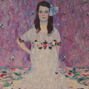 以下が含まれることがあります： 長い茶色の髪の若い女の子は、花柄の白いドレスを着て、髪に青いリボンをつけています。彼女は花柄の紫色の背景の前に立っています。