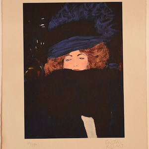 以下が含まれることがあります： 青い帽子と毛皮のコートを着た女性の白黒のプリント。女性の顔は帽子と毛皮で部分的に隠されています。プリントは右下に「グスタフ・クリムト」と署名され、左下に「39/150」と番号が付けられています。