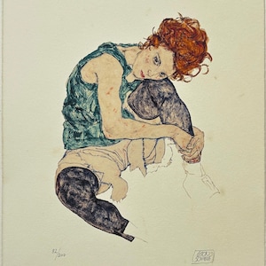 Könnte beinhalten: Ein Kunstdruck einer sitzenden Figur von Egon Schiele. Die Figur hat rotes Haar und trägt ein grünes Oberteil und schwarze Leggings. Das Kunstwerk ist mit 82/200 nummeriert und enthält die Signatur des Künstlers.