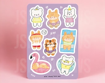 Peut inclure: Un ensemble de neuf autocollants en vinyle imperméables représentant de jolis animaux de dessin animé en tenue d'été. Les animaux comprennent un ours, un tigre et un renard. Les autocollants sont sur un fond violet avec des cœurs et le texte "aria "checky" turns one!" et "WATERPROOF VINYL STICKER".