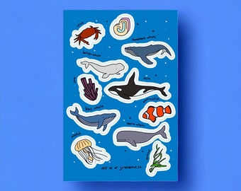 Peut inclure: Un ensemble d'autocollants d'animaux marins colorés représentant un crabe, une méduse, une baleine beluga, une baleine à bosse, une baleine bleue, une baleine à fanons, une orque et un poisson-clown. Les autocollants sont sur un fond bleu avec des points blancs et le texte "visit us at jerainbows.ca".