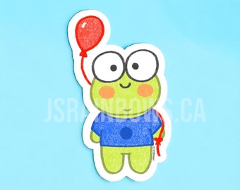 Peut inclure: Une grenouille verte portant des lunettes bleues et une chemise bleue avec un cercle blanc. La grenouille tient un ballon rouge.