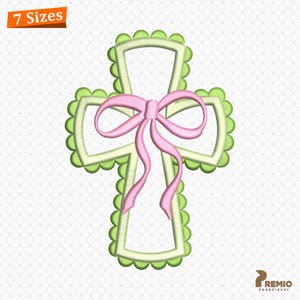 May include: An embroidered cross design with a light green scalloped border and a light green interior. A pink bow is centered on the cross. The words "7 Sizes" are in an orange rectangle in the upper left corner.
