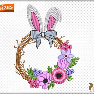 Puede incluir: Una corona floral con un lazo azul y orejas de conejo. La corona está hecha de ramas marrones y tiene flores rosas, moradas y blancas.