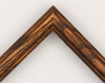 May include: Close-up of a dark brown wood picture frame with a slightly raised edge. The wood grain is visible and has a dark brown stain.