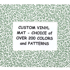 May include: A white background with a green leafy pattern. A white rectangle with black text reads "CUSTOM VINYL MAT - CHOICE of OVER 200 COLORS and PATTERNS".