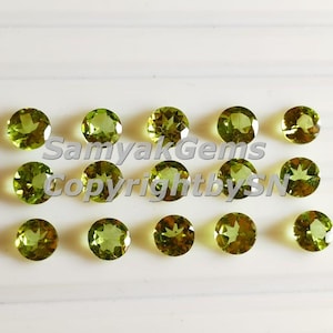 Könnte beinhalten: Eine Ansammlung von sechzehn runden, facettierten Peridot-Edelsteinen. Die Edelsteine sind von lebendiger, durchscheinender grüner Farbe und in vier Reihen auf einer weißen Oberfläche angeordnet. Der Text "Samyak Gems Copyright by SN" ist sichtbar.