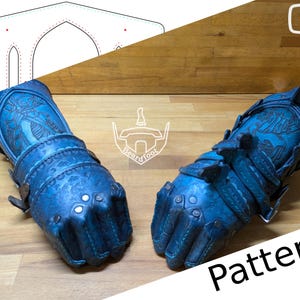 May include: A pair of blue leather arm guards with intricate designs and metal accents. The guards are shown on a wooden surface with a pattern for making them.
