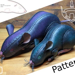 Può includere: Due sculture di ratto in pelle fatte a mano nei toni del viola e del verde acqua, con cuciture e baffi dettagliati. L'immagine include un diagramma del modello e la parola "Pattern". Le sculture sono su una superficie di legno.