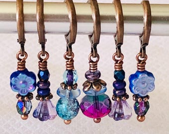 Puede incluir: Seis marcadores de punto de cobre con cuentas de vidrio azul, morado y turquesa. Cada marcador tiene una cuenta con forma de flor y una cuenta de cristal.